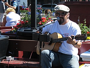 A man singing and playing the guitar at Pier 49